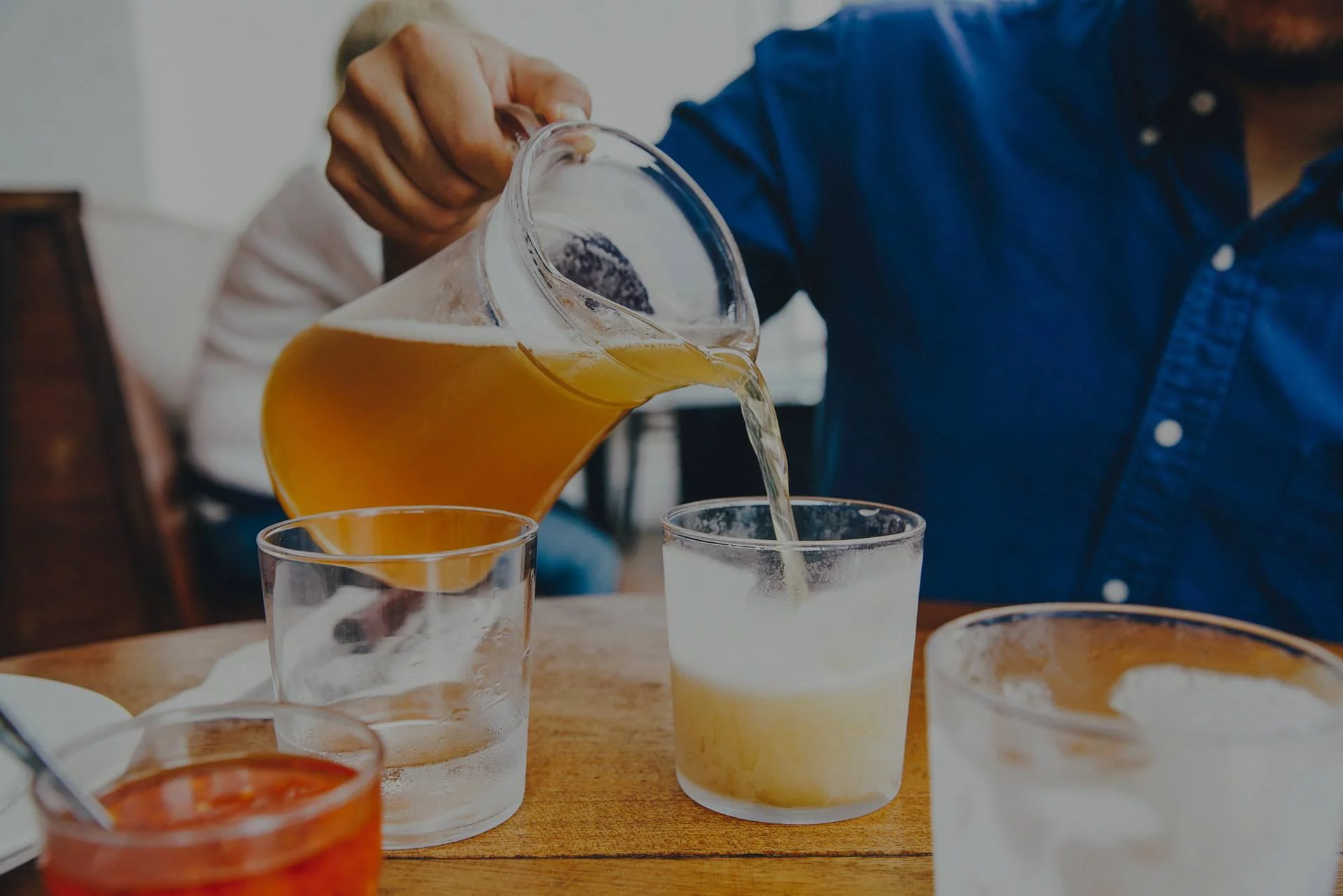 man pouring dink into a glass